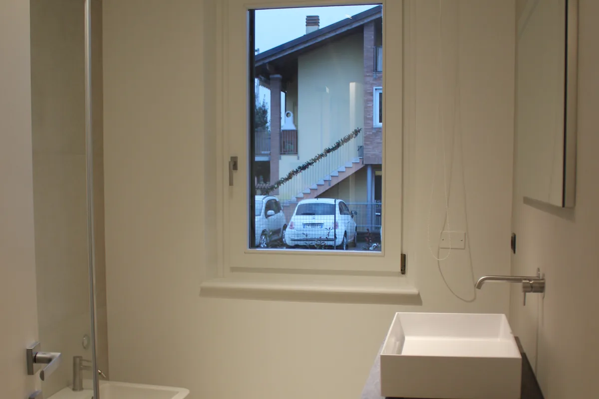 Bagno ristrutturato con rivestimenti in ceramica e box doccia in vetro