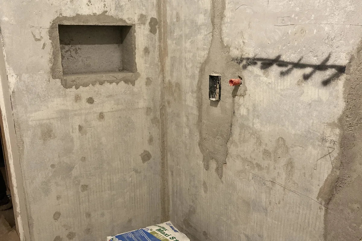 Ambiente in corso di ristrutturazione con murature a vista e impianti in traccia